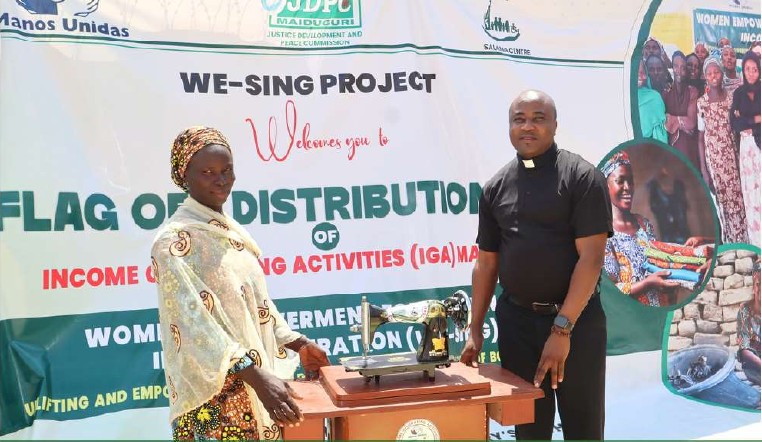 A woman receiving a livelihood start-up kit at a WE-SING project distribution