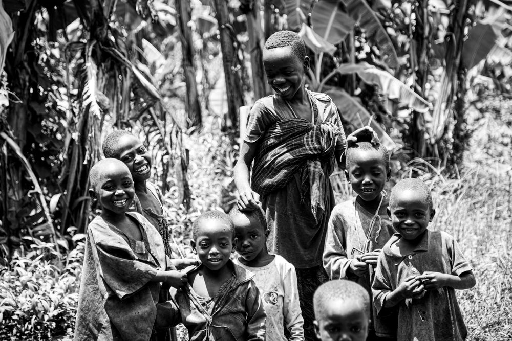 A group of African children smiling amidst lush nature