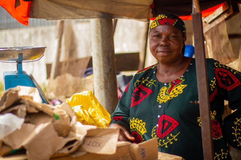 A smiling African woman vendor at her outdoor market stall