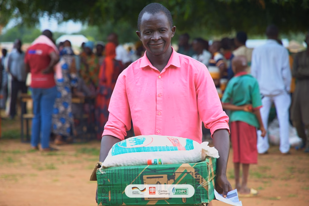 A man holding a food assistance package at a community gathering